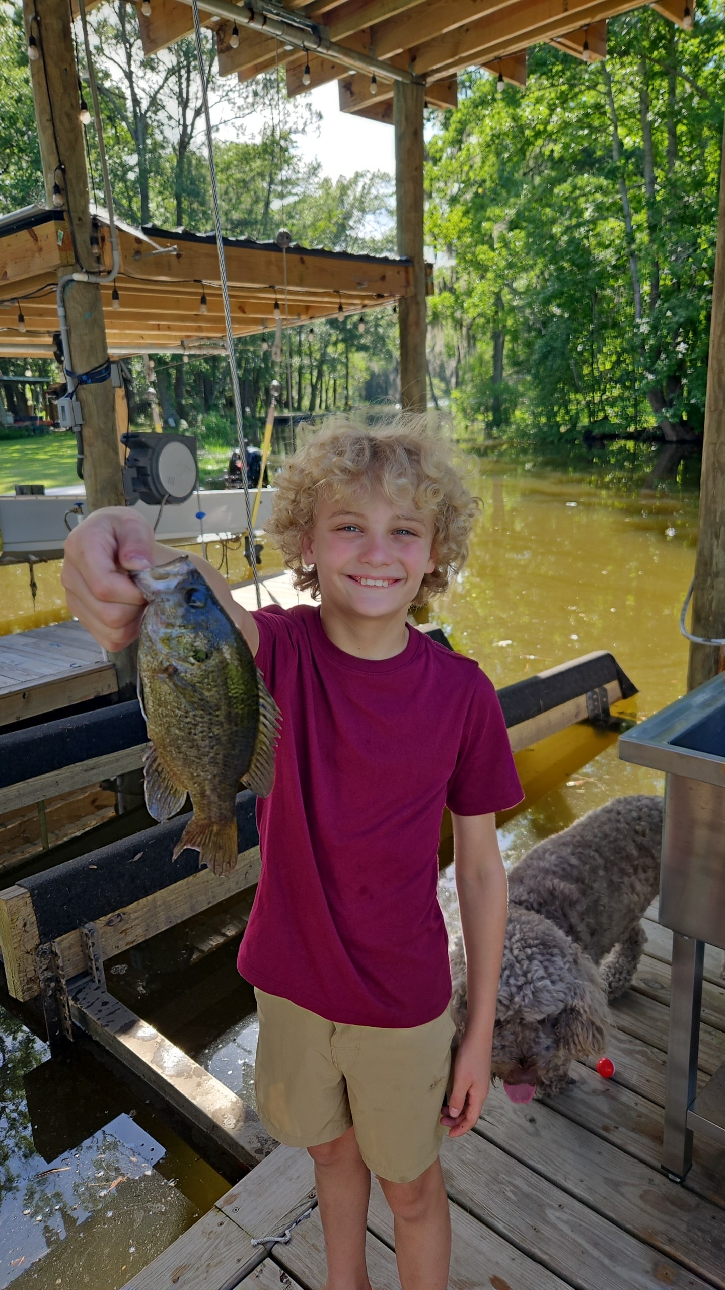 Eli holding a fish he caught on Dog River